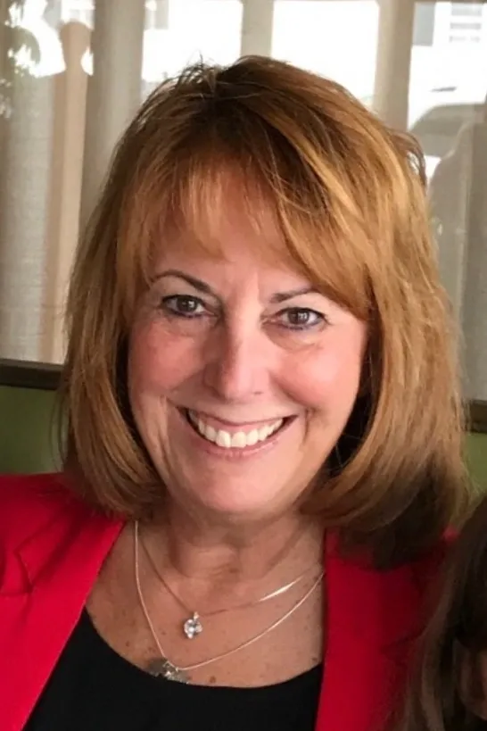 A woman with red hair and a smile.